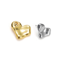 Load image into Gallery viewer, Side view of two-tone layered heart stud earrings showcasing the silver heart ear jacket worn behind the earlobe and the polished gold heart stud in front.
