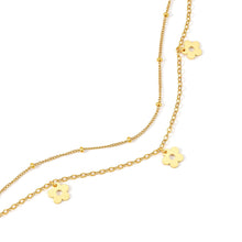 Load image into Gallery viewer, Close-up of a layered daisy flower charm necklace showcasing delicate floral charms, petite petal details, and a modern double-layer gold chain.
