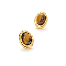 Load image into Gallery viewer, Top view of sculpted gold oval stud earrings with genuine tiger's eye gemstones, featuring an artistic organic-inspired silhouette and polished finish.
